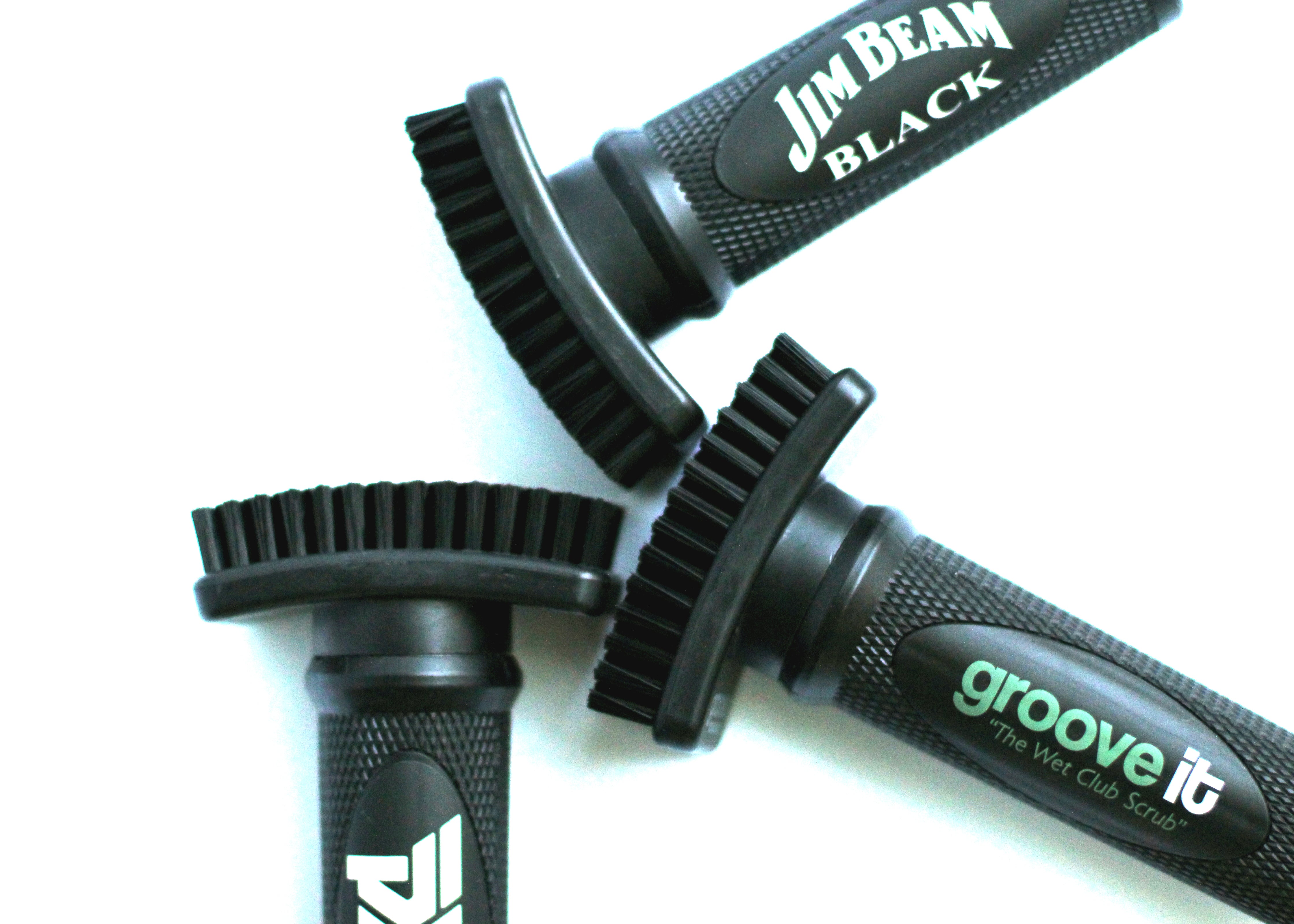 Close-up of three custom Grooveit golf brushes featuring Jim Beam Black, Grooveit, and another branded logo, arranged on a white background.